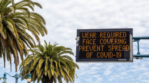 Digital signage in San Francisco in May 2020 with a reminder to wear face coverings to prevent the spread of COVID-19.