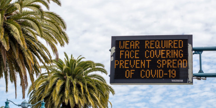 Digital signage in San Francisco in May 2020 with a reminder to wear face coverings to prevent the spread of COVID-19.