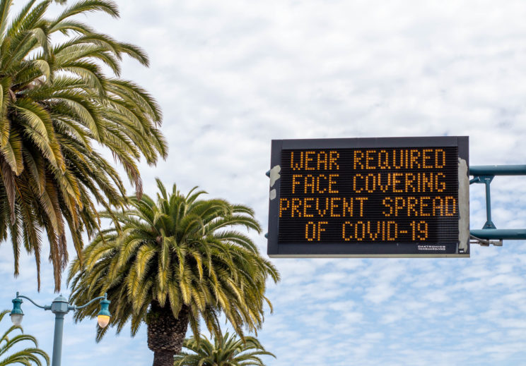 Digital signage in San Francisco in May 2020 with a reminder to wear face coverings to prevent the spread of COVID-19.