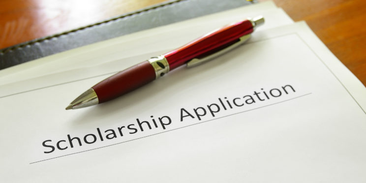 a pen on top of a scholarship application