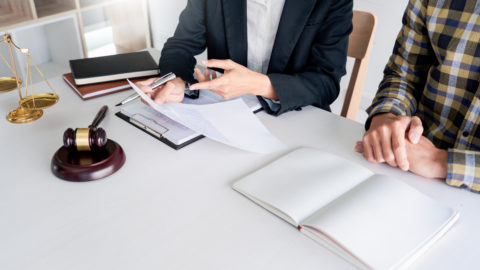 Business people and lawyers discussing contract papers sitting at the table