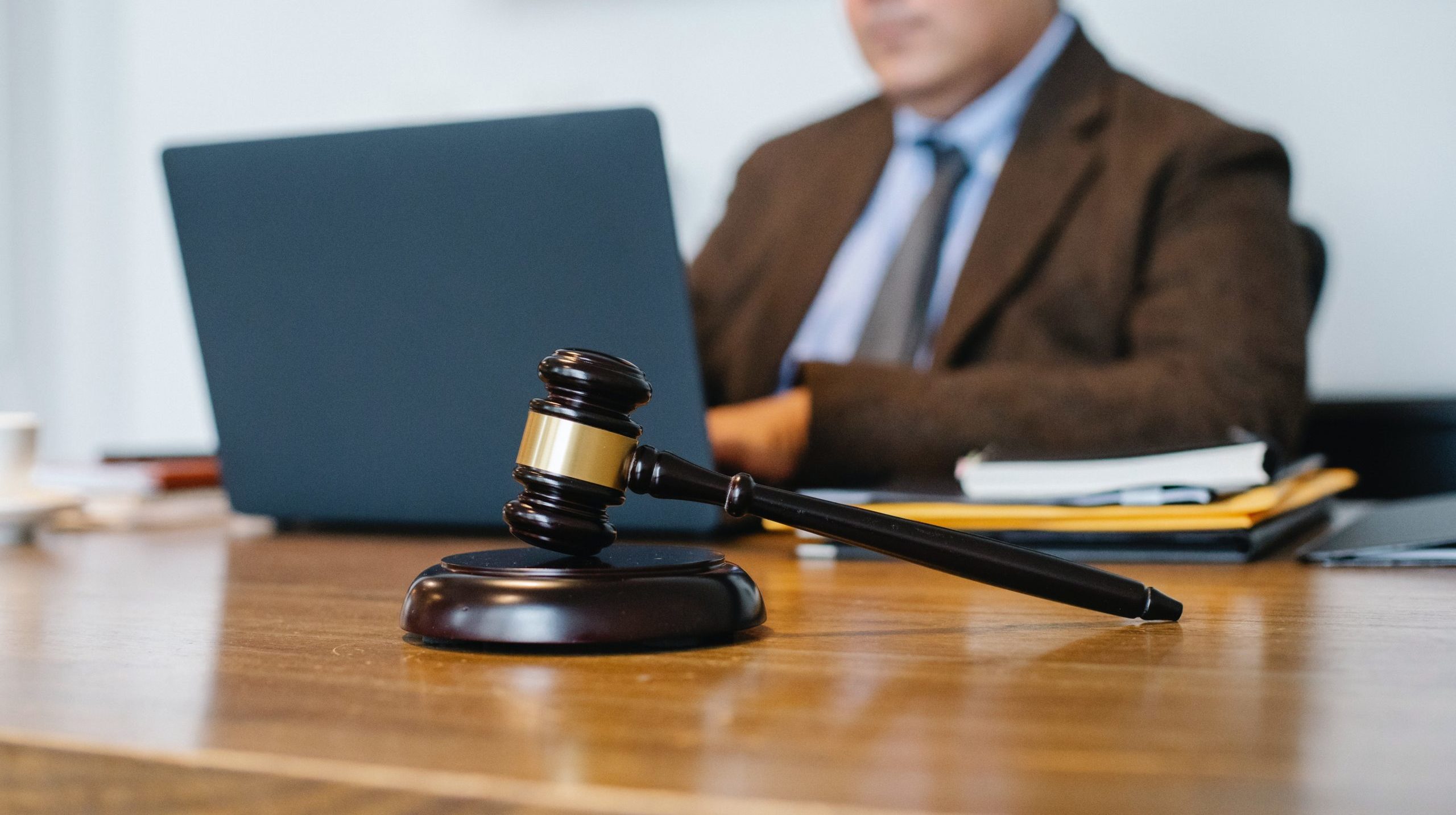 lawyer writing on laptop with gavel and books on the desk