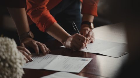 Two people signing documents