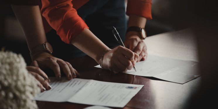 Two people signing documents