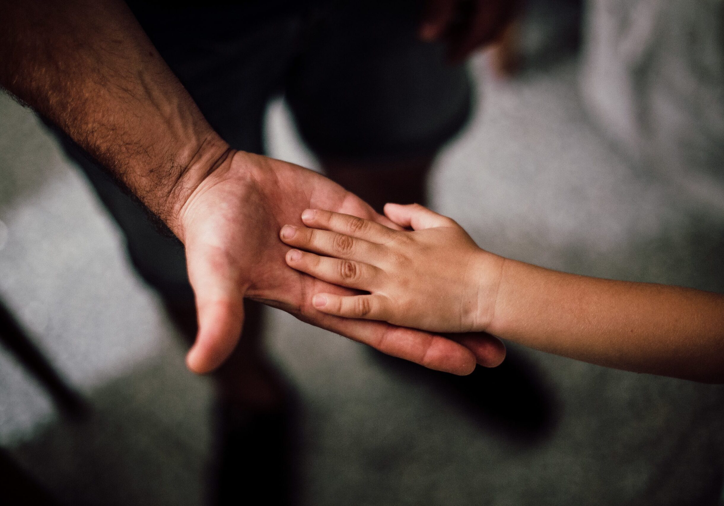 Child put their hand on their parent's hand